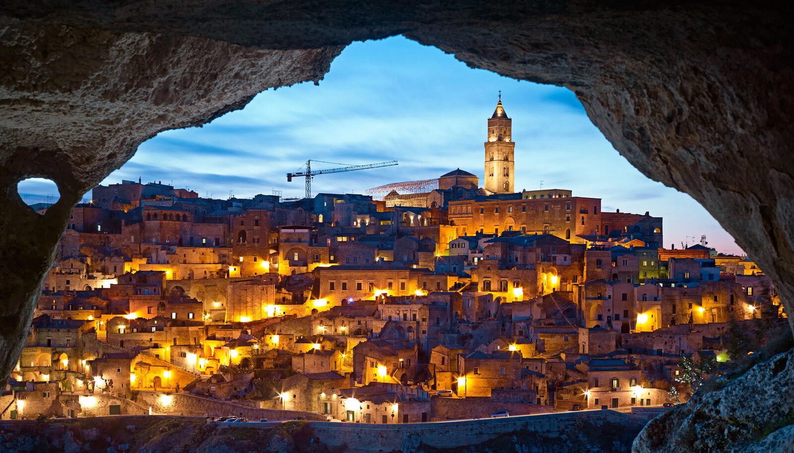 The Sassi of Matera glowing at night, one of the oldest continuously inhabited cities in the world