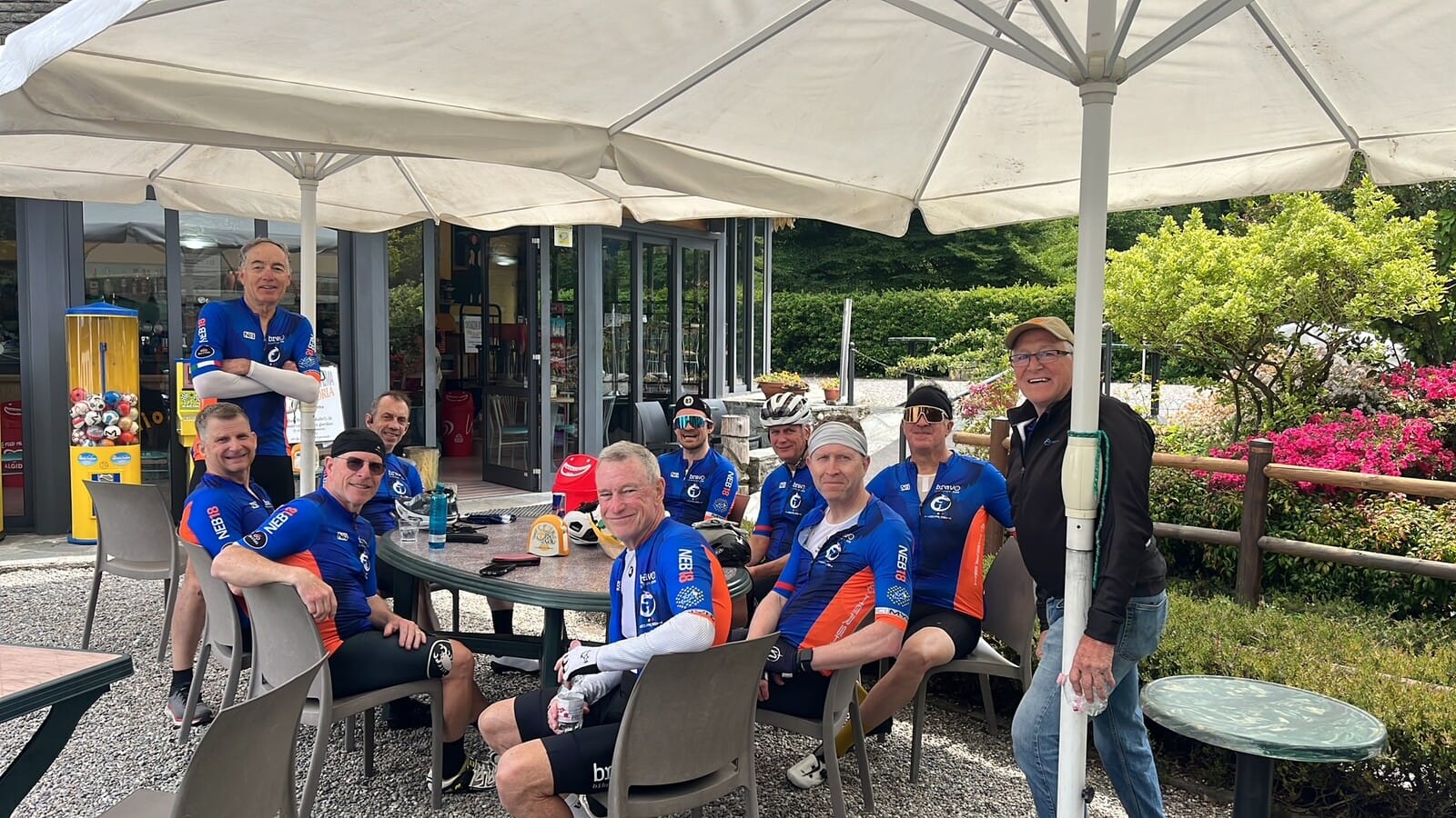 Group lunch stop under an umbrella near the Ghisallo