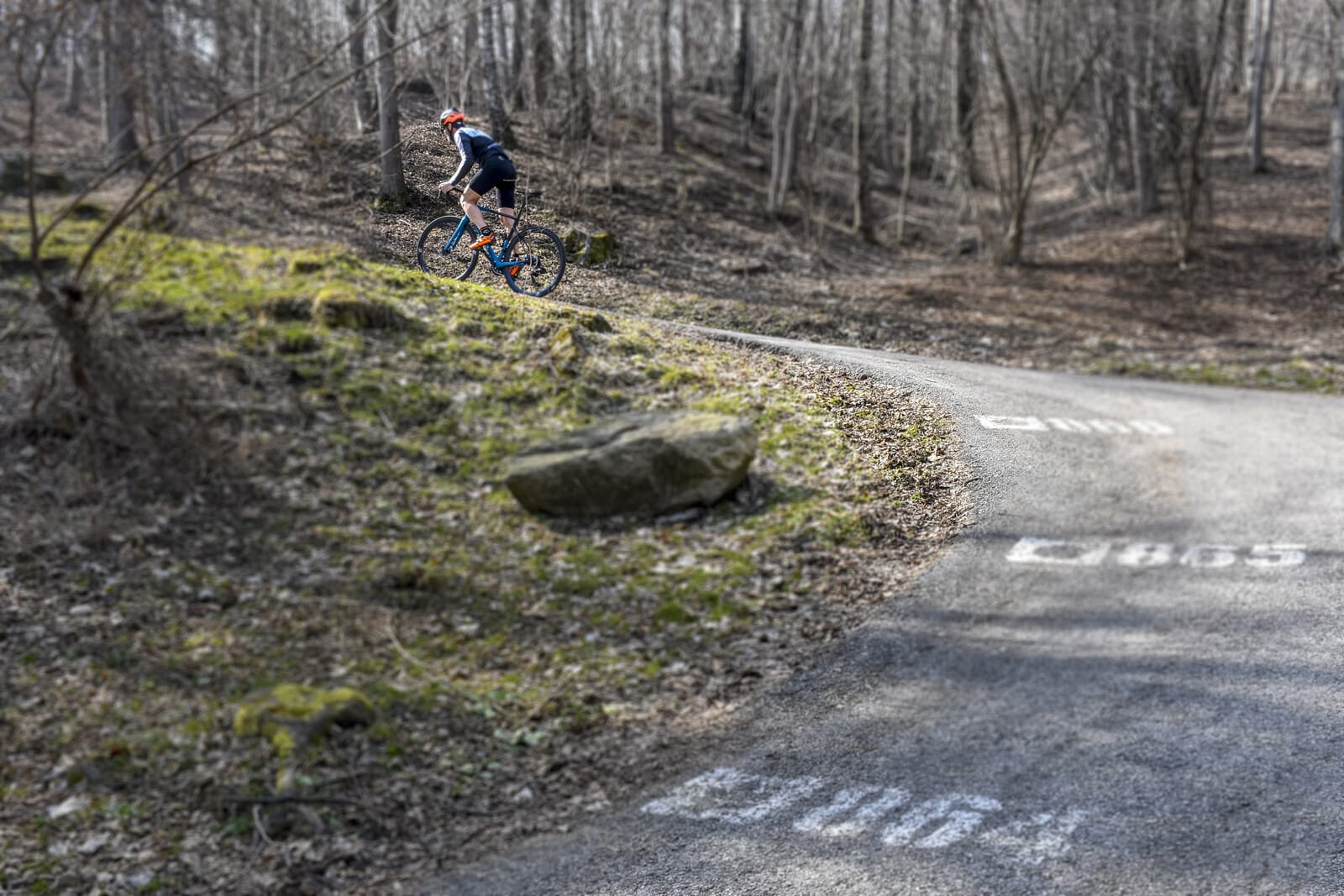 Cyclist climbing a steep road near Lake Como
