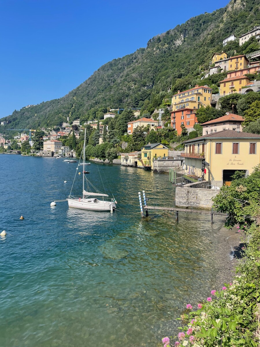 Lakeside village with boats moored along the shore