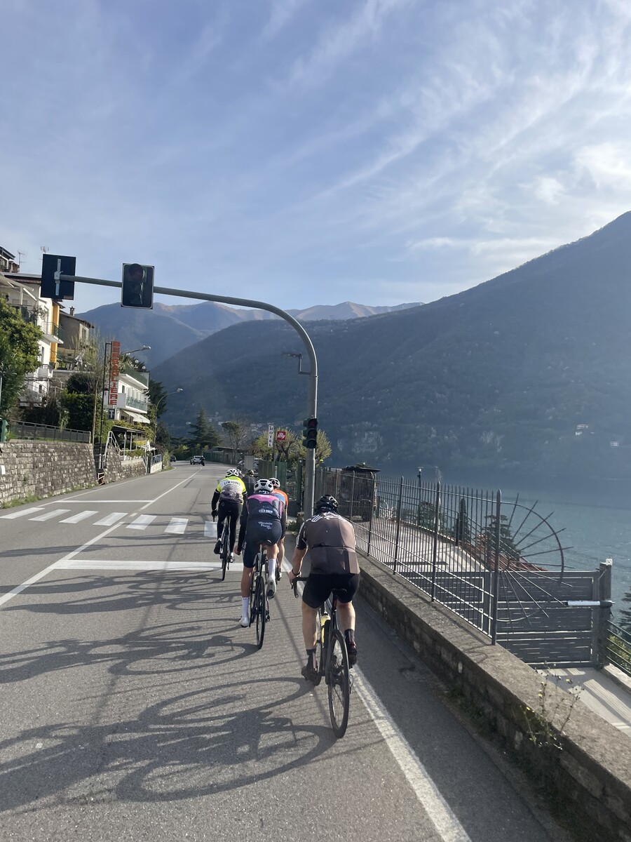 Cyclists riding on a scenic road above Lake Como