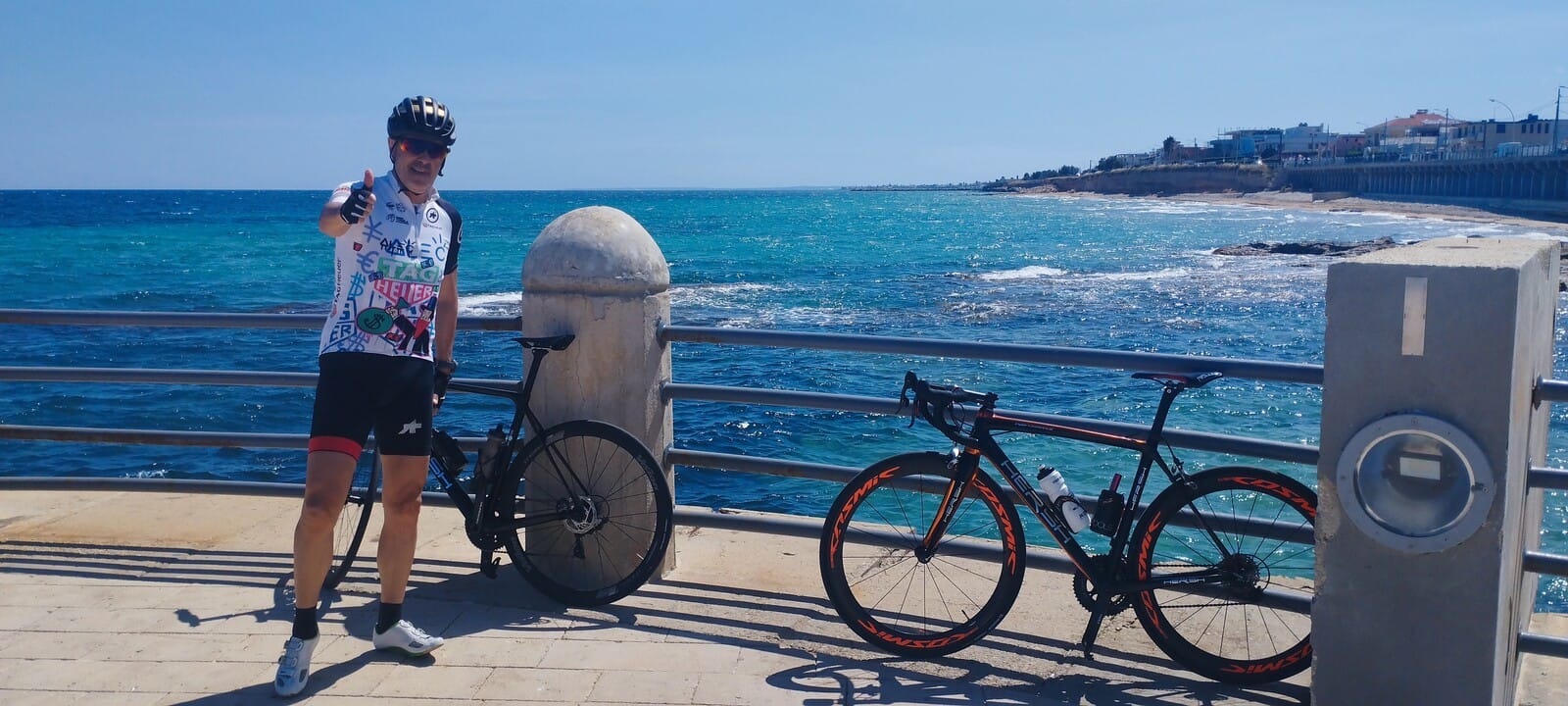 Cyclist with bike on the seafront promenade in Syracuse