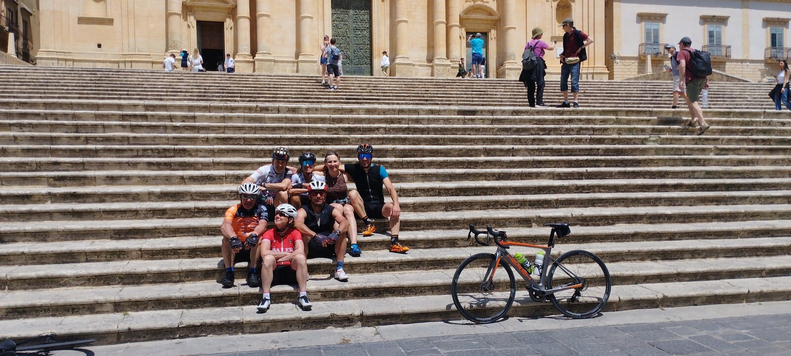 Cyclists resting on a baroque staircase in Sicily