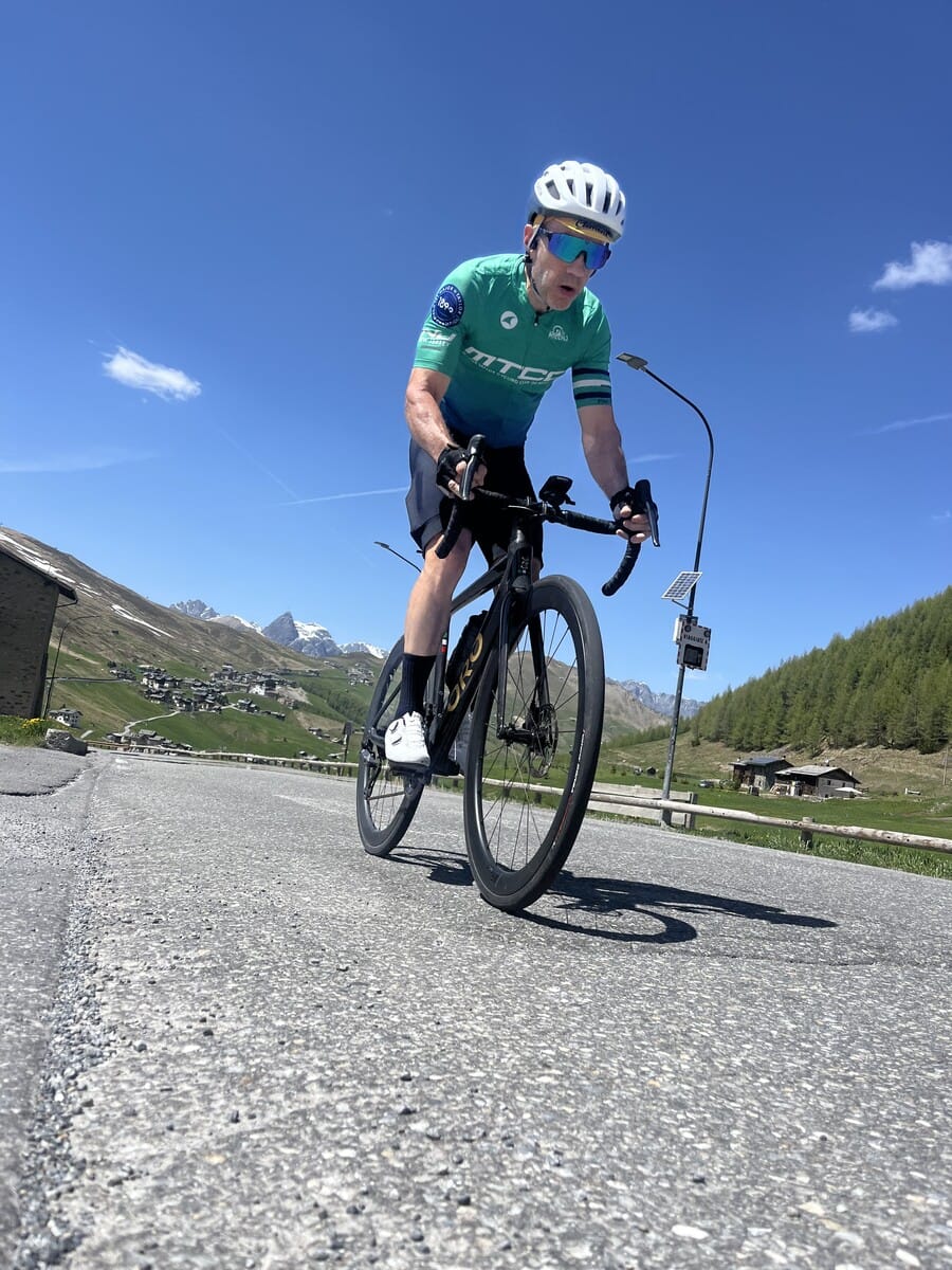 Cyclist celebrating at the summit of Passo di Foscagno